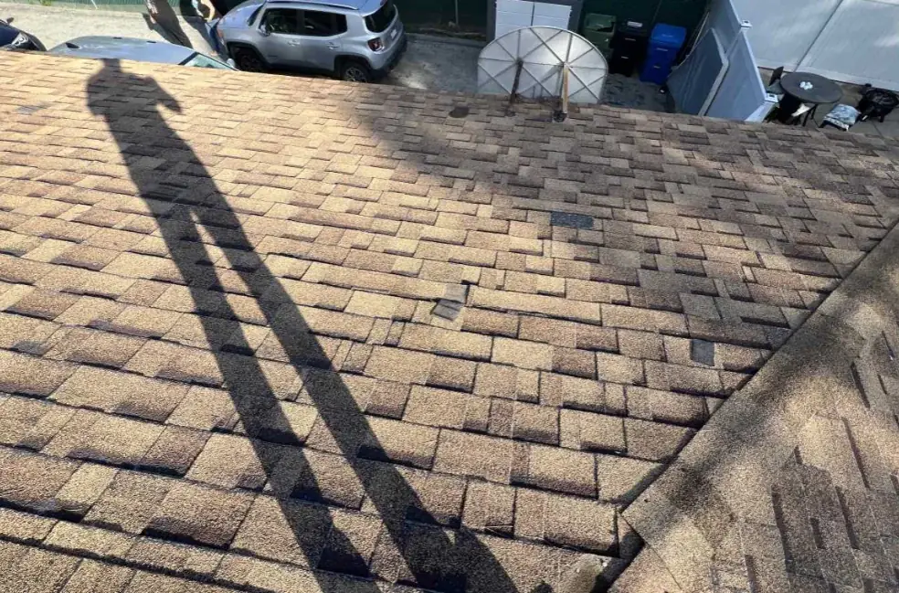 Missing and displaced shingles across the roof